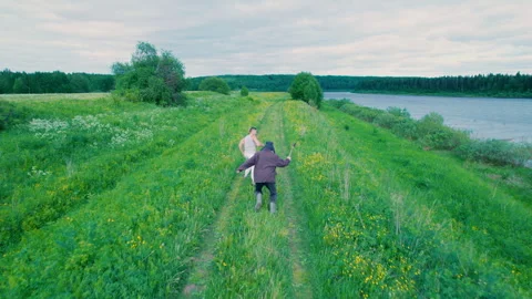 A man runs after a guy and threatens him with an axe. Aerial photography. Stock Footage 311312591