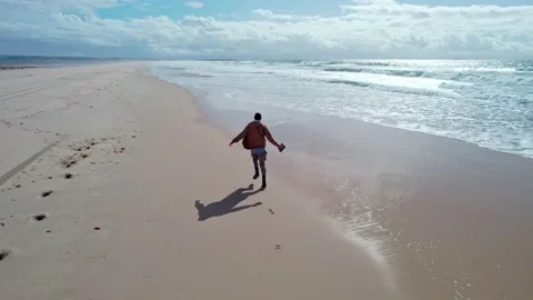 A man runs along the beach along the ocean Stock Footage 231472609