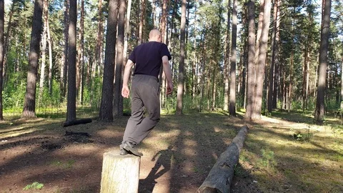A man runs along a log in the forest slow motion. 스톡 동영상 108176441