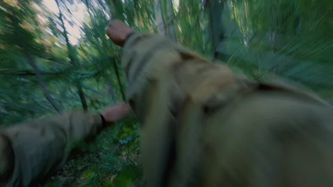 A man runs away from danger in the forest and climbs a fallen tree. Stock Footage 342001957