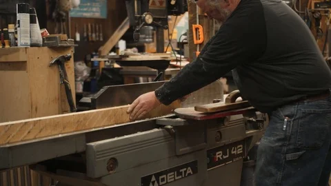 Man runs board through jointer machine Stock Footage 102044974