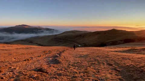 Man runs down on mountain on a beautiful sunset Video stock 166363853