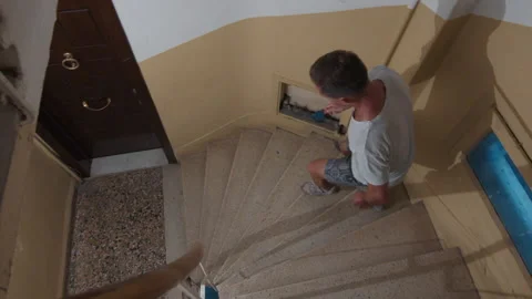 Man runs down on stairs inside the old residential building. Young man runs down Video stock 249860934