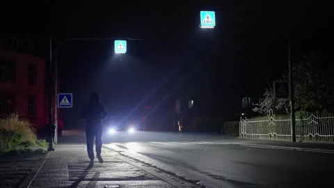 A man runs down the street and drops his mobile phone. during nighttime in an Video stock 307434846