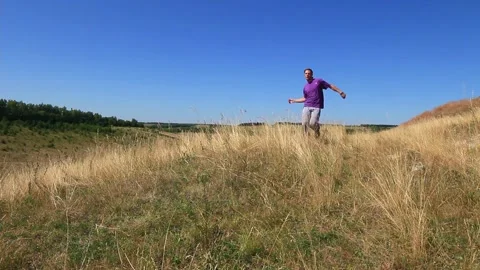 The man runs into the field and returns, doing somersaults Stock Footage 158012376