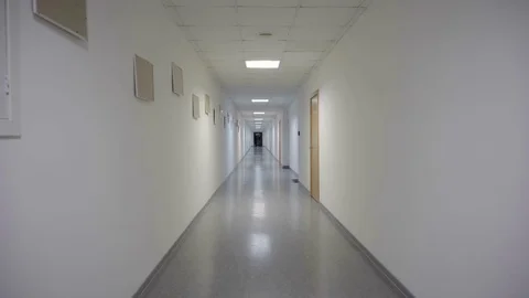 Man runs a long white corridor Stock Footage 72431871