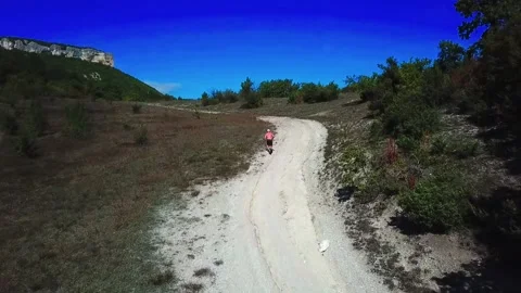 A man runs up a mountain Stock Footage 169872673