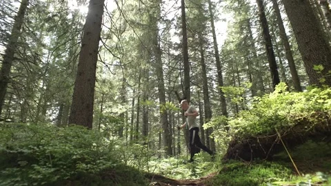 A man runs in a mountain forest. Trail of a boy on the edge of nature. Stock Footage 217395810