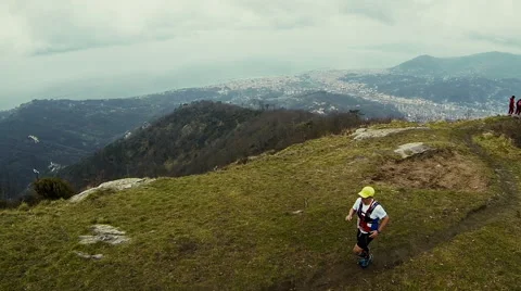 A man runs on a mountain ridge overlooking the sea Video stock 59796238