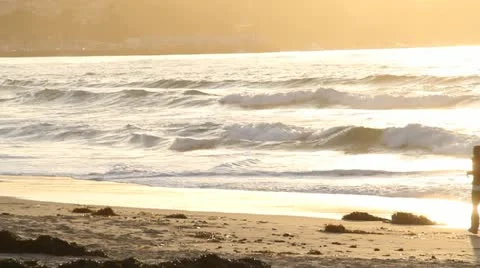 Man runs on ocean beach at sunset Stock Footage 21541827
