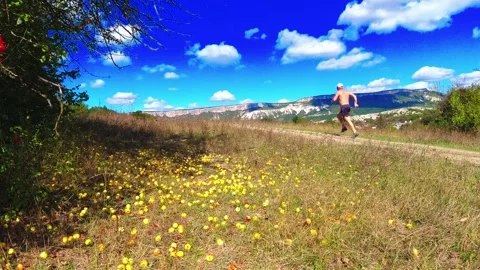 A man runs past a fruit tree Stock Footage 169872336