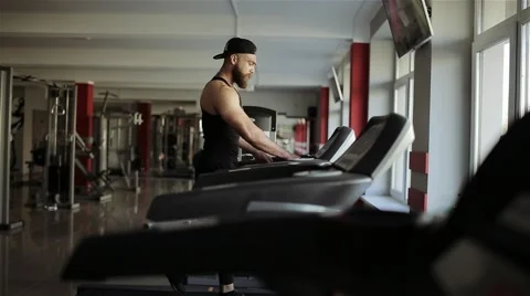 A man runs on a running machine in the gym Stock Footage 56636055