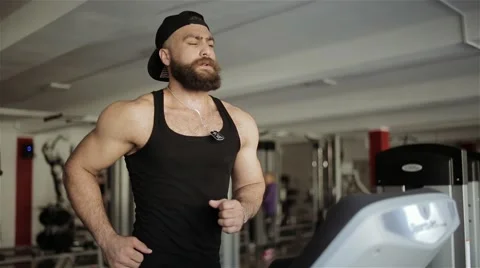 A man runs on a running machine in the gym Stock Footage 56636083