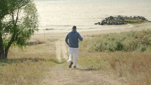 A man runs to the sea. Video stock 209571479