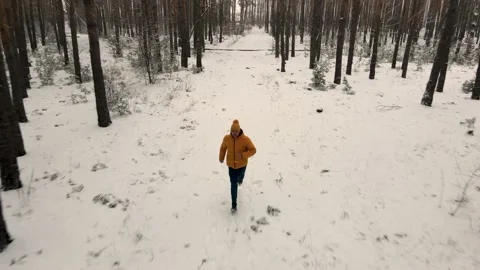 A man runs in a snow-covered forest alone facing the camera Video stock 169014298