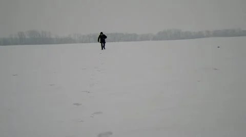The man runs on snow towards. Stock Footage 22348193