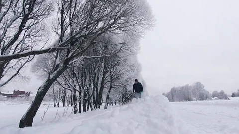 Man runs through deep snow in the winter in the park Video stock 85027628