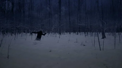 Man runs through the forest at night in the winter. Stock Footage 87341357