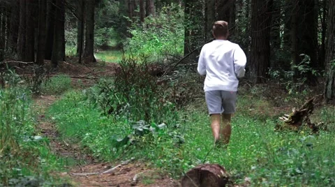 A man runs through the green forest Stock Footage 54647589