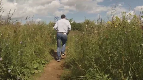 A man runs through a meadow of grass Video stock 79028485