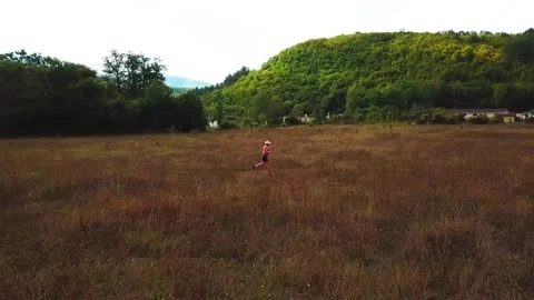 A man runs through a meadow side view Stock Footage 169872405