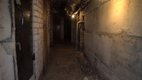 Man runs through an old abandoned building, basement with lantern. 库存影片 117361394