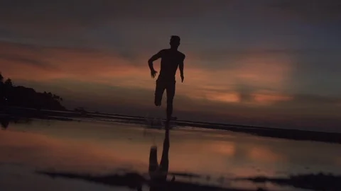 Man Runs Through Reflective Pool at Sunset Slow Motion Stock Footage 106784202