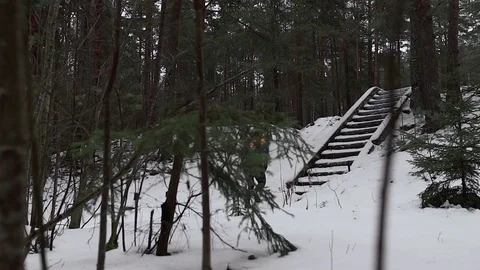 A man runs through the winter forest and climbs running up the stairs Stock Footage 129639217
