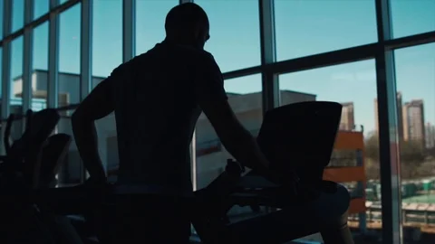 Man runs on a treadmill on a window background 스톡 동영상 88830107