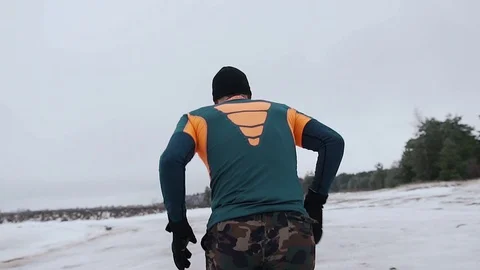 A man runs in winter from behind 動画素材 129639209