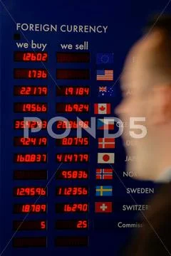 Man rushing past a currency board Stock Photos