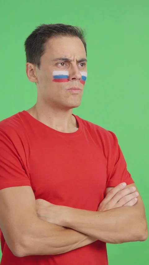 Man with russian flag painted looking away with serious expression Stock Footage 258827817