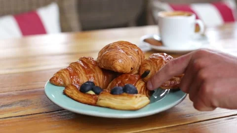 A man 's hand slowly picks up a croissant Stock Footage 270769091