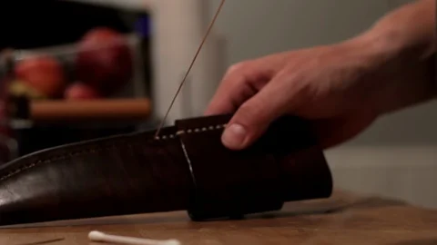 Man saddle stitching a leather knife sheath, Medium close up Stock Footage 95597342