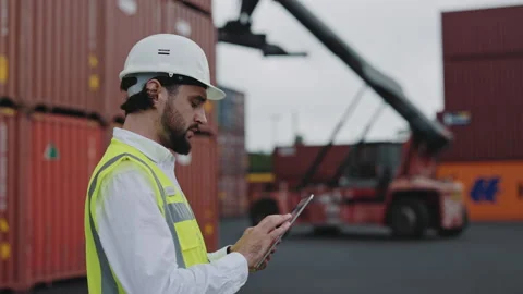 Man in safety helmet using tablet at dock warehouse Stock Footage 167224862