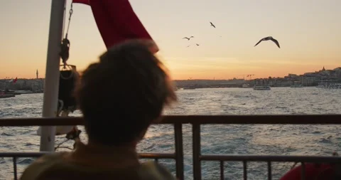 A man sails on a ship past the city during sunset. Sunset in the Bosphorus Stock Footage 239363757