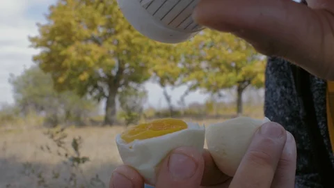 Man salt boiled egg holding in his hand. close-up boiled eggs in a male hand Stock Footage 117186757