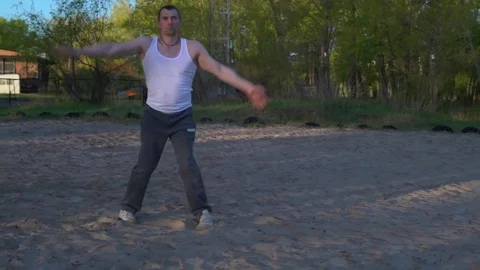 The Man on the Sand Practicing the Kata of Karate in the Early Morning in the Stock Footage