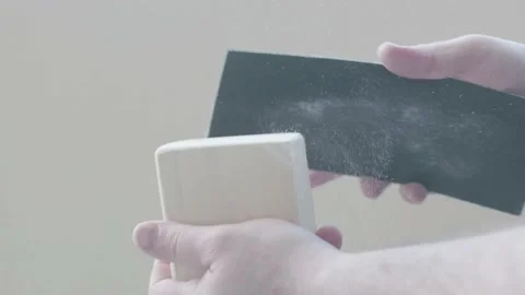 Man sanding cube of wood block with a black sand paper Stock Footage
