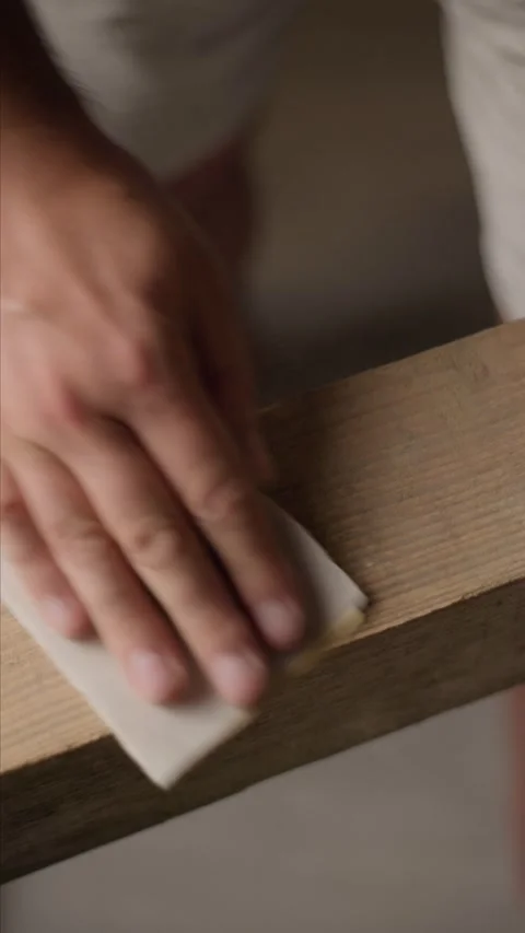 Man sanding raw timber plank with sandpaper Stock Footage 344601411