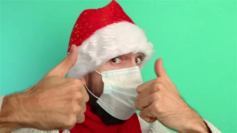 Man in santa hat  and face mask having fun dancing showing thumbs up Stock Footage 143125891