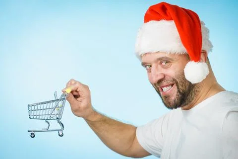 Man in santa hat holds empty shopping cart Foto stock