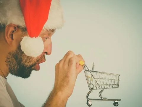 Man in santa hat holds empty shopping cart Stock Photos