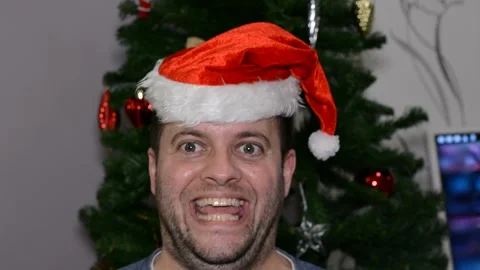 A man in a santa hat makes a face.  close-up Video stock 145123563