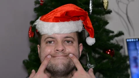 A man in a santa hat makes a face.  close-up Stock Footage 145124074