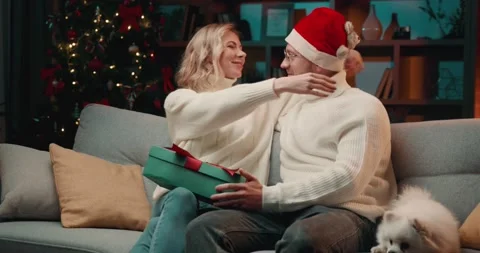 Man in Santa hat making Christmas gift to his girlfriend Video stock 222467882