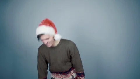 Man in Santa hat opening gift box unexpectedly hand from a box grabs him by nose Stock Footage 70223519