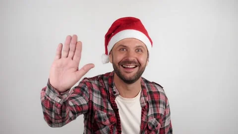 A man in a Santa hat waves and greets. Vídeo Stock 143951297
