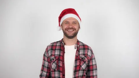 A man in a Santa hat waves and greets. 動画素材 143987734
