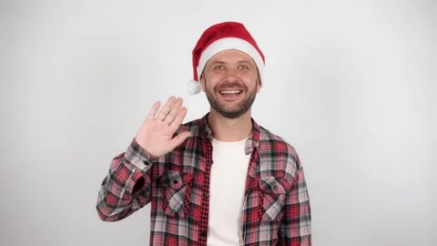 A man in a Santa hat waves and greets. Celebration amid the coronavirus pandemic 스톡 동영상 143987825